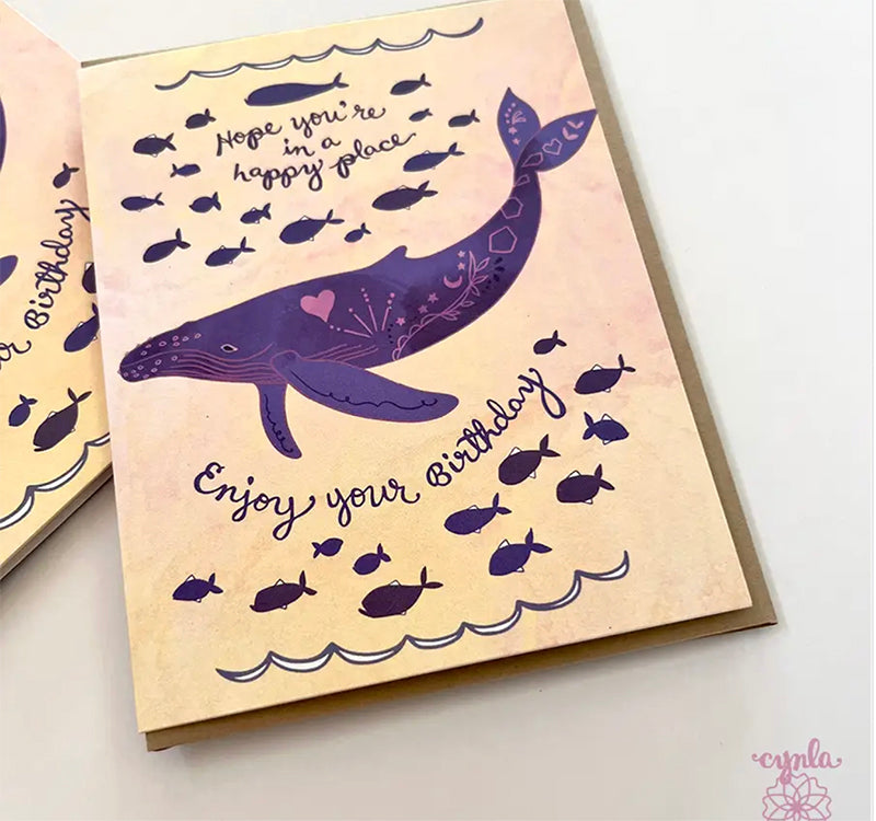 Greeting card with a purple whale illustration and text on a light background